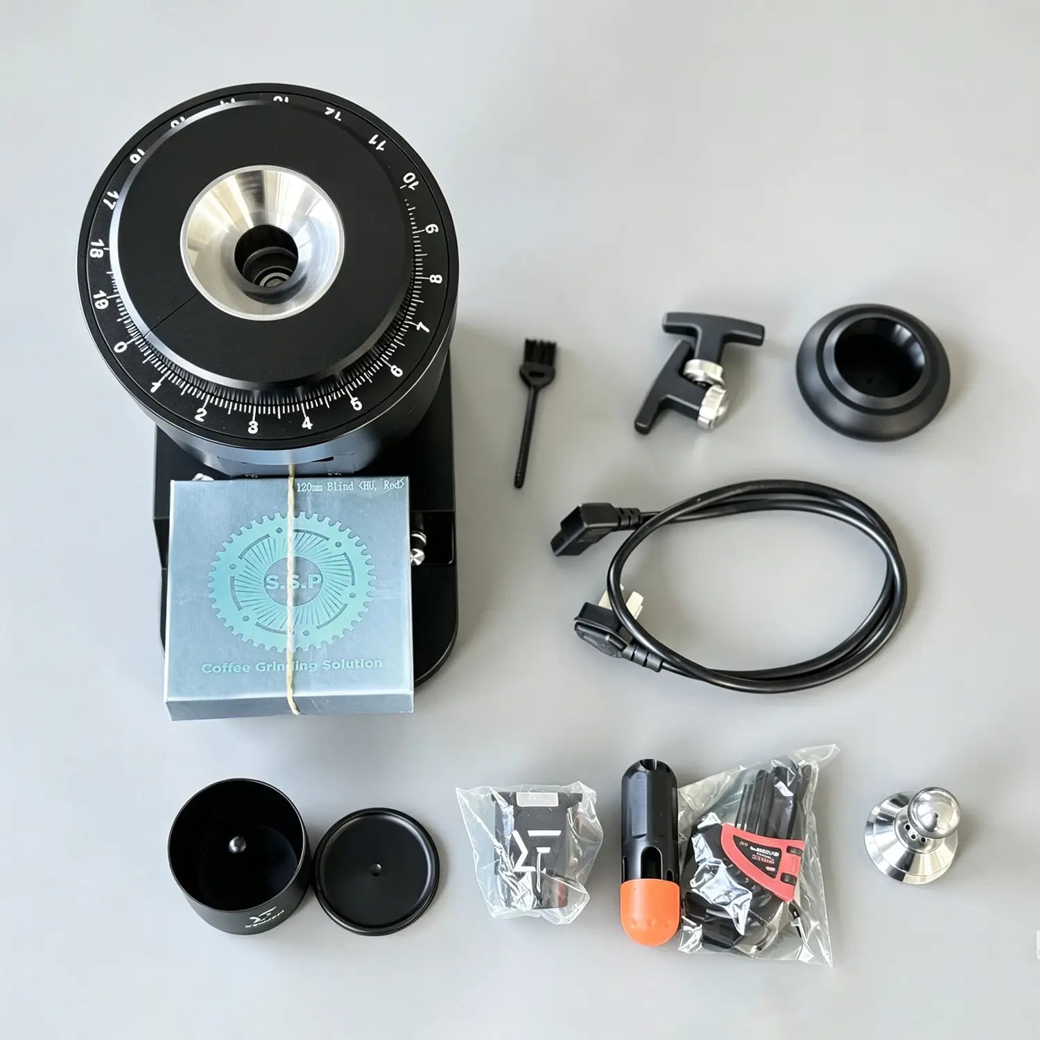 Top view of a 120mm premium single dose coffee grinder with SSP flat burrs package and maintenance tools